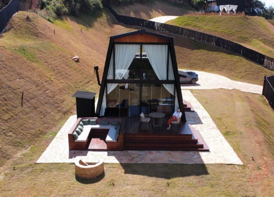 Chalé Gold com deck de madeira, lounge externo e vista aberta para o vale