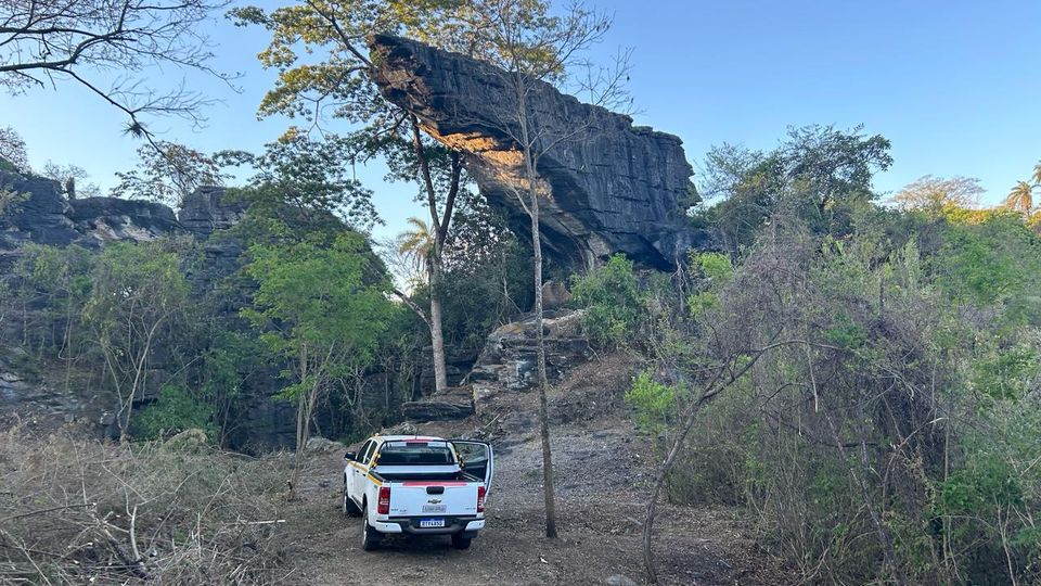 Grande formação de pedra em balanço sobre o caminho de terra