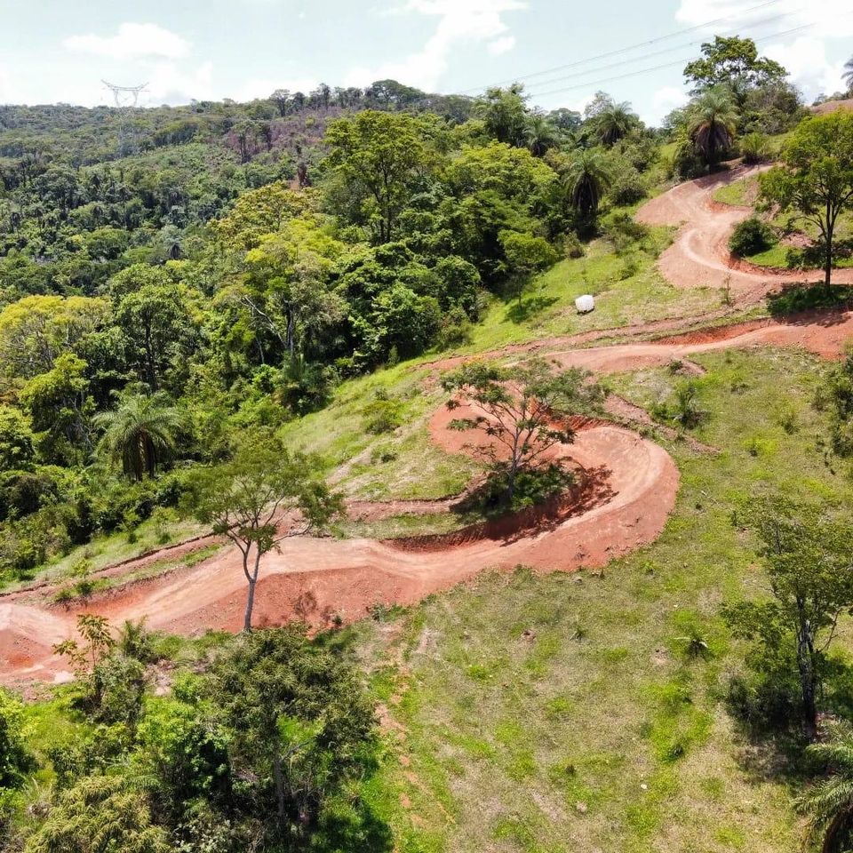 Vista aérea das trilhas de terra em curvas dentro da mata
